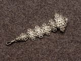 un gros plan d'un bracelet en argent posé sur une surface marron