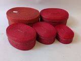 six red round wicker boxes stacked on top of each other