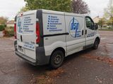 a white van parked in a parking lot with trees in the background