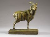 bronze statue of a goat on a wooden base against a gray background