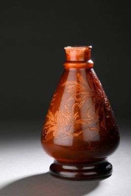 un vase marron posé sur une table sur fond noir