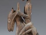 an image of a wooden statue of a man riding a horse