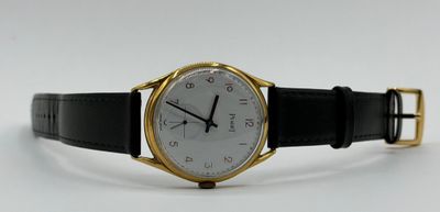 an image of a gold and black watch on a white background