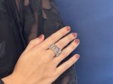 someone is wearing a black dress and a ring on their finger