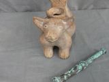 a cat figurine sitting next to a toothbrush on a table