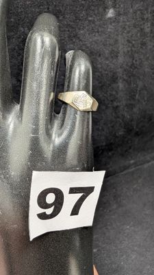 une main à laquelle est passée une bague sur laquelle figure un chiffre