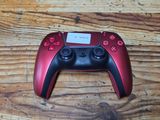 a red and black game controller sitting on a wooden table