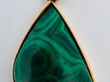 un gros plan d'un pendentif vert sur une surface blanche