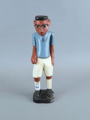 figurine représentant un homme vêtu d'une chemise bleue et d'un short blanc