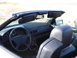 a white car with black leather seats and a steering wheel