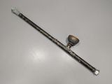 an old pipe sitting on top of a white table next to a wooden stick