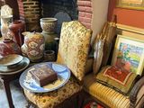une pièce avec une cheminée, un fauteuil, une table et des tableaux accrochés au mur