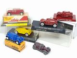 four toy cars in a display case on a white surface