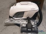 a vacuum that is sitting on the ground next to a box