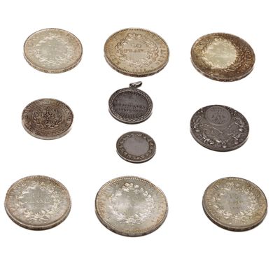plusieurs types de pièces de monnaie sont présentés sur une surface blanche
