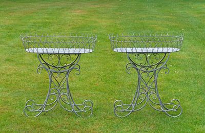deux jardinières en métal posées sur l'herbe dans le jardin