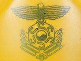 a yellow vase with a tattoo of a bird on it
