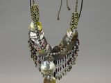 a close up of a necklace on a stand on a white background