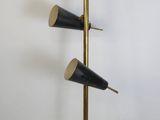 un grand lampadaire en laiton et noir, muni de trois lampes noires