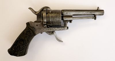 gros plan d'un revolver sur une surface blanche