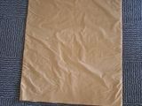 a brown paper bag on the floor next to a pair of scissors and a pair of scissors