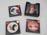 trois sous-verres sur lesquels figurent l'image d'une femme et d'un coq