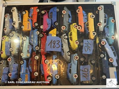 une collection de petites voitures exposée dans une vitrine posée sur une table