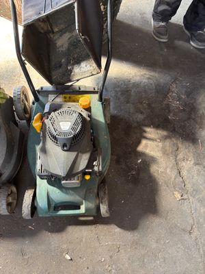 a lawn mower that is sitting on the ground next to a trash can