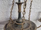 an antique brass plated chandelier with two candles and a candle holder