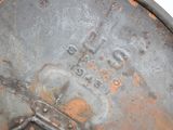 a rusted metal lid with a crown on it
