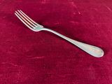 a silver fork on a red cloth with a red background
