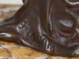 a bronze statue of a dog on a marble table