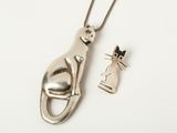collier en argent avec une breloque en forme de chat suspendue à une chaîne