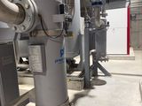 pipes and valves in a large industrial building with a yellow line on the floor