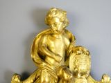 a gold statue of a boy and a dog on a table