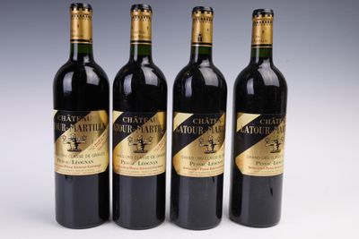 quatre bouteilles de vin sont alignées sur une surface blanche