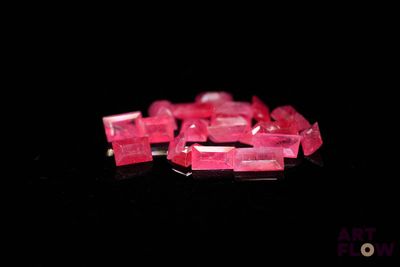 de très jolis cristaux roses posés sur une surface noire