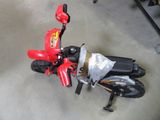 a small red motorcycle that is sitting on the floor