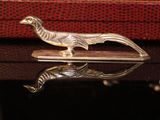 a silver bird sitting on top of a piece of luggage