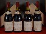 three bottles of red wine are lined up on a table