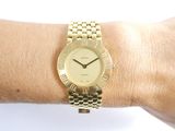a gold wrist watch on a woman ' s wrist