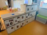 several white refrigerators are stacked on top of each other in a room