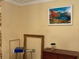 a dresser and a mirror in a room with a painting on the wall