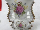 a white vase with a floral design on it