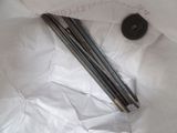 four metal rods in a bag on a white surface