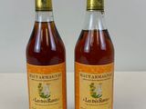 deux bouteilles d'alcool posées l'une à côté de l'autre sur une table