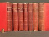 several old books are lined up in a row on a table