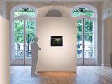 a sculpture in the middle of a room with a large window