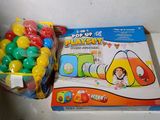 une boîte de jouets et un sac de balles posés sur une table
