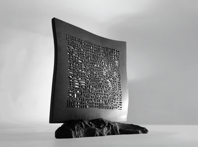 une photo en noir et blanc d'une sculpture posée sur un rocher